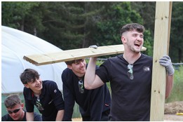 Men smiling and holding lumber