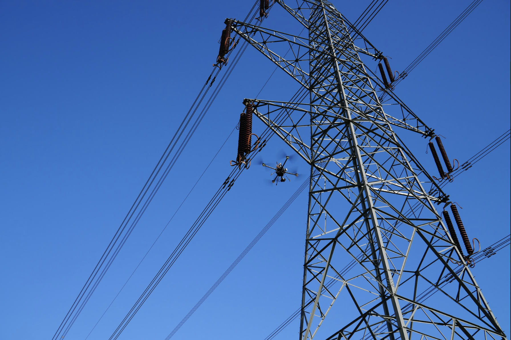 A drone working near a transmission tower