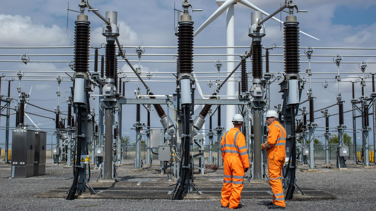 Two engineers wearing orange high-vis overalls and hard hats at Bicker Fenn Substation