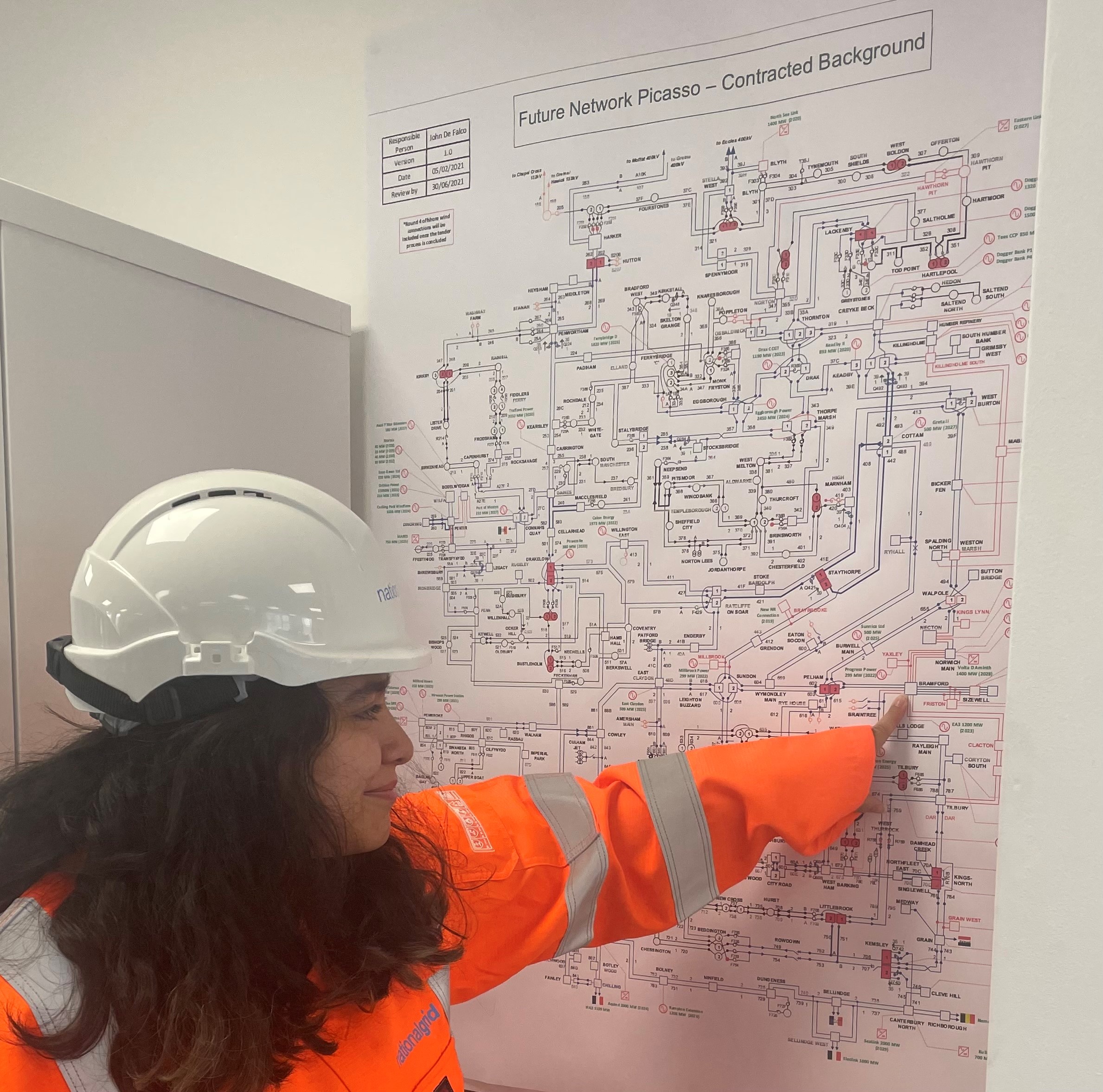 National Grid's Tanya Bukhari wearing PPE and pointing at a diagram on the wall
