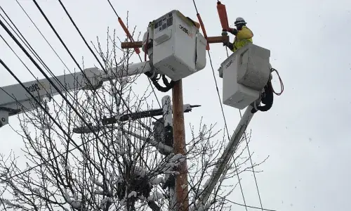 National Grid lineworker fixing a power line in the snow in the US