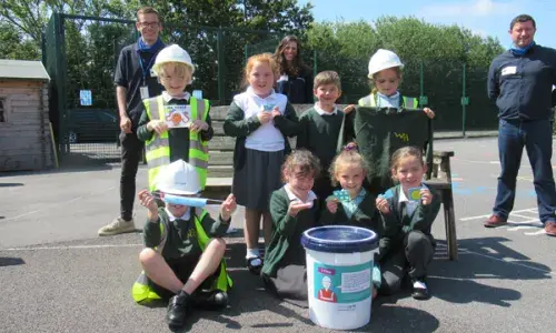 Group of school children preparing a time-capsule to put inside a T-pylon