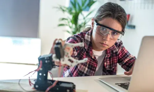 Young girl working with robotics for National Grid 'Inspiring female engineering talent story' for INWED