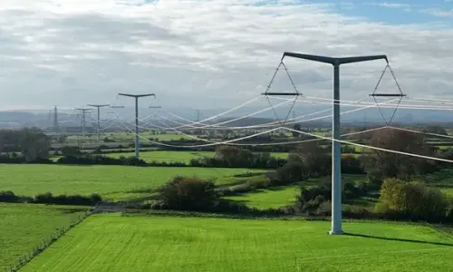 T-pylons and overhead electricity lines across green fields