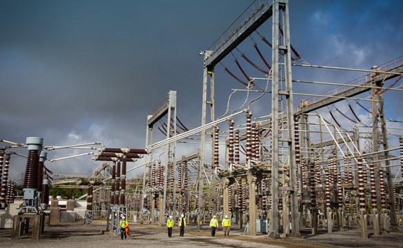 Engineers wearing PPE walking through an electricity substation