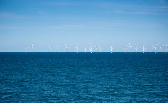 Wind farm in the distance at sea for National Grid 'Green loan speeds race to net zero' story