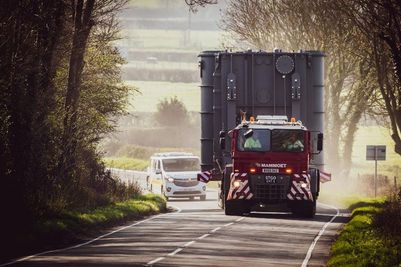 Series reactor being delivered to Shurton Substation - 2 New series reactor on lorry on narrow road followed by escort vehicle