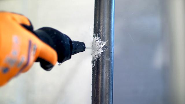 MoltenMetalManipulation_StoppingSF6Leaks_640x360.jpg A gloved hand holding a drill, drilling into a metal pipe