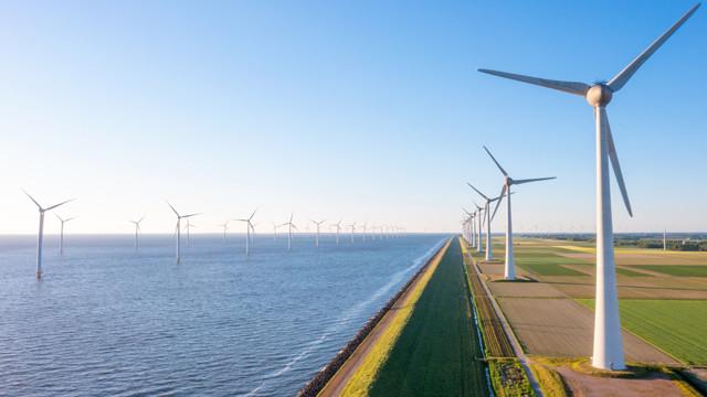 OnshoreVsOffshoreWindPower_640x360.jpg Wind turbines along a shoreline and offshore wind farm